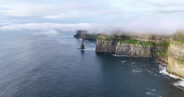 Anne kıyı kayalıklarının alçak bulutlarla örtülü hava görüntüleri. Resimli altın saat manzarası. Moher, Clare, İrlanda uçurumları. Yüksek kalite 4k görüntü
