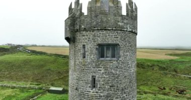 Havadan. Clare County 'de çim çayırlarıyla çevrili Doonagore taş kale kulesi. İrlanda. Hava aracı tamam. Yüksek kalite 4k görüntü