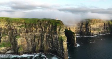 Alçak bulutlarda gizlenmiş kıyı kayalıklarının hava görüntüleri. Resimli altın saat manzarası. Gün batımı. Moher, Clare, İrlanda uçurumları. Yüksek kalite 4k görüntü