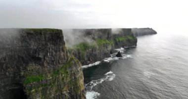 Anne kıyı kayalıklarının alçak bulutlarla örtülü hava görüntüleri. Moher, Clare, İrlanda uçurumları. Yüksek kalite 4k görüntü