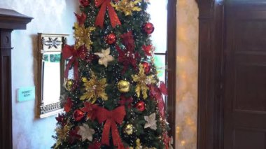 Klasik Yeni Yıl Ağacı aydınlandı. Grunge Room 'da Noel süslemesi şömineli, at sallanan çocuk sandalyeli. Yüksek kalite 4k görüntü