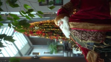 Oyuncak Noel Baba. Kırmızı şapkalı Noel Baba. Beyaz sakallı Noel Baba. Noel Baba 'nın güzel bir Noel geçmişi var. Dekorasyonları ve sönmüş ışıkları var. Dikey. Yavaş Hareket.