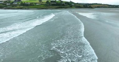 Havadan. Resimli plajın oradaki sahil şeridi. Mavi suları ve beyaz dalgaları olan resimli bir sahil şeridi. Inchydoney Sahili. Clonakilty, County Cork, İrlanda. Ağır çekim. Yüksek kalite 4k görüntü