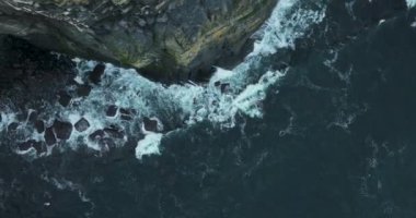 Havadan. Tiftik yamaçlarının kayalık kıyısı. Kamera suya doğru iniyor. Beyaz dalgalar yüksek kayalara çarpar. Clare, İrlanda. Yüksek kalite 4k görüntü