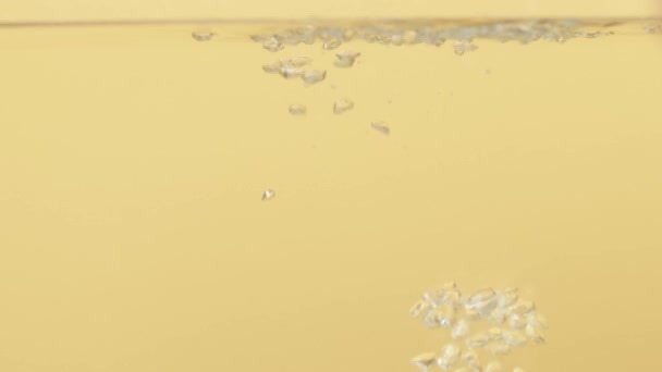 Vzduchové Bubliny Vodě Stoupají Vzhůru Žlutém Pozadí Vysoce Kvalitní Fullhd — Stock video