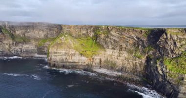 İrlanda 'nın kırsal kesimlerinden gelen Clare County' nin turistik merkezi The Cliffs of Moher ve Burren Ireland. Vahşi Atlantik yolu boyunca İrlanda 'nın destansı deniz manzarası. Güzel manzaralı İrlanda 4k