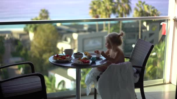 一个可爱的小女孩在一个露天宾馆的阳台上吃早餐 可以看到迷人的海景 完美的早晨Alanya Turkey 2021高质量4K镜头 — 图库视频影像