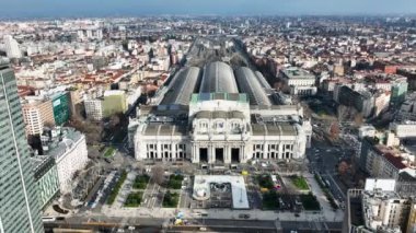 Milano Merkez Tren İstasyonu ve çevresindeki meydanın tarihi binasının havadan görünüşü. İstasyonun hava görüntüsü. Turizm. Yüksek binalı bir siluet. İtalya, Milan. Yüksek kalite 4k görüntü