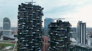 Modern ve çevre dostu gökdelenlerin balkonlarında bir sürü ağaç olan havadan görünüşü. Bosco Verticale. Mimarlık, dikey bahçeler, teraslar. Yeşil Gezegen Yüksek kalite 4k görüntü