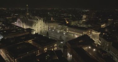 Merkezdeki gotik katedralin önündeki Piazza Duomo 'nun hava manzarası. Gece uçuşu var. Duomo 'nun merkez kulesindeki Meryem Ana heykelinin havadan görünüşü. Milan, İtalya