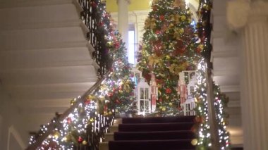 Işıklar ve oyuncaklarla süslenmiş Noel ağacı. Noel ve Yeni Yıl iç dekorasyonu. Oyuncaklarla süslenmiş yeşil ağaç, hediyeler, hediye kutuları, yanıp sönen çelenkler, yanan lambalar. Samimi Noel