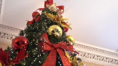 Kapatın. Peri masallarındaki dayanılmaz bir Noel ağacı. Eski moda iç mekan. Noel ağacı. Noel ağacı tavana ulaşıyor. Yılbaşı ağacı eski bir evde lüks bir yerde.
