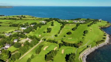Okyanus ve Plaj yakınlarındaki Güzel Lüks Yaşam Tarzı Costal Golf Sahasının 4K Hava Dronu. Okyanusun yakınındaki kayalık bir kayalıkta resim gibi bir golf sahası. Gold Coast Golf Kulübü. Waterford Köyü