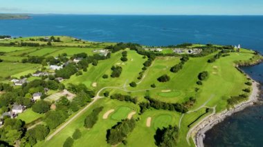 Okyanus ve Plaj yakınlarındaki Güzel Lüks Yaşam Tarzı Costal Golf Sahasının 4K Hava Dronu. Okyanusun yakınındaki kayalık bir kayalıkta resim gibi bir golf sahası. Gold Coast Golf Kulübü. Waterford Köyü