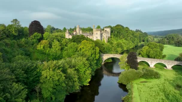 エアリアル 川岸にある城 アイルランドのウォーターフォードにある城 夕暮れの太陽が城を照らしている リスモア城とノックメルタウン ウォーターフォードアーランズ古代東部の緑豊かな田園地帯 — ストック動画