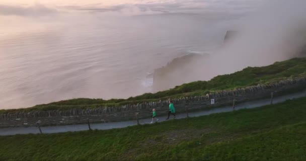Antenne Touristen Gehen Entlang Der Nebligen Straße Der Cliffs Moher — Stockvideo