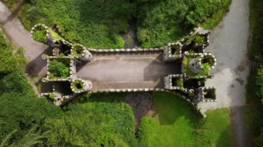 Ireland 'ın Ballysaggartmore Kulelerinin insansız hava aracı görüntüsü. Gizemli kulelerin üzerinde uçuyor. Lismore İlçesi Waterford Ormanı 'ndaki ortaçağ köprüsü. Mistik bir mekan. Ortaçağ binası. Geçit kapısı.