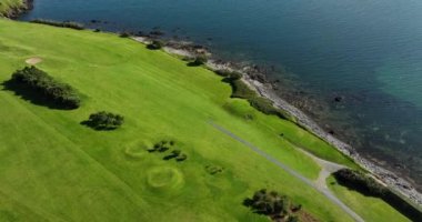 Okyanus ve Plaj yakınlarındaki Güzel Lüks Yaşam Tarzı Costal Golf Sahasının 4K Hava Dronu. Okyanusun yakınındaki kayalık bir kayalıkta resim gibi bir golf sahası. Gold Coast Golf Kulübü. Waterford Köyü