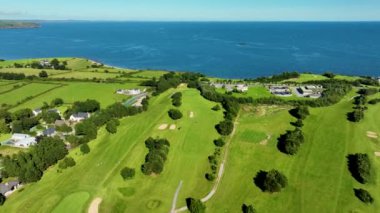 Okyanus ve Plaj yakınlarındaki Güzel Lüks Yaşam Tarzı Costal Golf Sahasının 4K Hava Dronu. Okyanusun yakınındaki kayalık bir kayalıkta resim gibi bir golf sahası. Gold Coast Golf Kulübü. Waterford Köyü