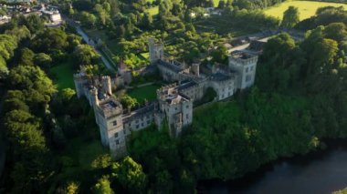 Havadan. Nehir kıyısındaki kale. Waterford, İrlanda 'daki Lismore Kalesi. Akşam güneşi Castle. Waterford Ireland 'ın verimli kırsalındaki Lismore Kalesi ve Knockmealdown Dağları Antik Doğu