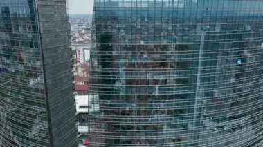 Ofis binası pencereleri ve gökdelen binasının hava manzarası. Birçok başarılı şirketlerin ofisleri var. Şehir bir gökdelenin pencerelerinde sergileniyor. Kiralık ev ve...