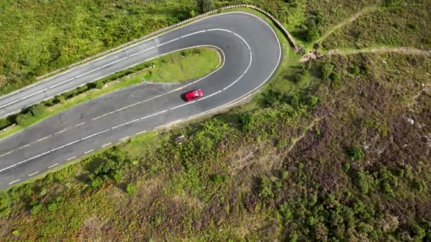 山の蛇行道路を巻き上げる急なターンを通して運転する車 美しい緑豊かな春の風景の狭い高速道路 赤い車は山道に鋭いターンが入ってくる ノックマイヤルタウン — ストック動画