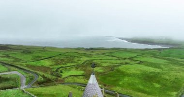 İrlanda 'nın batı kıyısındaki güzel Doonagore Kalesi' nin üzerindeki hava manzarası. İrlandalı vahşi Atlantik yolu boyunca ünlü turistik cazibe. Doonagore Kalesi, Doolin, County Clare, İrlanda. Yüksek