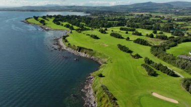 Okyanus ve Plaj yakınlarındaki Güzel Lüks Yaşam Tarzı Costal Golf Sahasının 4K Hava Dronu. Okyanusun yakınındaki kayalık bir kayalıkta resim gibi bir golf sahası. Gold Coast Golf Kulübü. Waterford Köyü