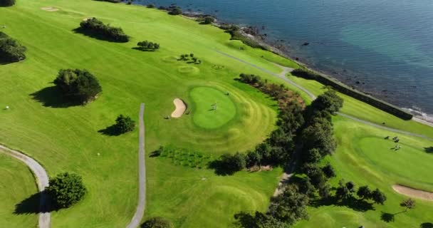 4K空中无人机电影美丽奢华的生活风格海滨高尔夫球场靠近海洋和海滩 在靠近海洋的岩石悬崖上的一个风景如画的高尔夫球场 黄金海岸高尔夫俱乐部 沃特福德 — 图库视频影像