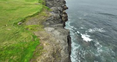 Okyanus dalgaları kayalık sahili yıkıyor. County Clare 'deki İrlanda' nın kırsal bölgelerinden gelen hava aracı. Moher ve Burren İrlanda Kayalıkları. Vahşi Atlantik yolu boyunca İrlanda 'nın destansı manzaralı deniz manzarası