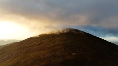 Üzerinde büyük bir bulut olan güzel dağların hava görüntüleri. İrlanda 'daki Glenveagh Ulusal Parkı. Yürüyüş için mükemmel bir yer. Yüksek bir dağda gün batımı. Nakavt Dağları, Tipperary ve