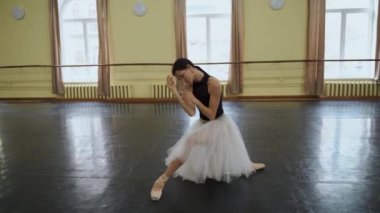 Sivri uçlu ayakkabılı balerin ve tiyatronun prova salonunda dans edip prova yapan beyaz etekli balerin. Zarif bir klasik bale dansçısı koreografi yapar. Kyiv, Ukrayna 2019. Yüksek kalite 4k