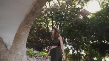 Güzel bir kadın parkta yürüyor. Kadın yürüyüşü, doğal güzellik, şehir sokağı. Güneşli, sıcak bir günde genç bir kadının portresi. Şehirde yürüyen güzel bir kadın, kente gülümseyen hippi bir kız.