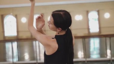 Dairesel. Kapatın. Profesyonel bir balerin salonun ortasında güzel hareket eder. Plastik el hareketleri, plastik el hareketleri. Dans stüdyosundaki genç klasik dansçı kadın. Bale sınıfı