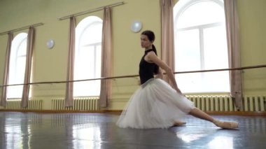 Sivri uçlu ayakkabılı balerin ve tiyatronun prova salonunda dans edip prova yapan beyaz etekli balerin. Zarif bir klasik bale dansçısı koreografi yapar. Kyiv, Ukrayna 2019. Yüksek kalite 4k
