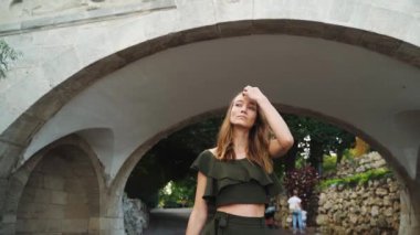 Güzel bir kadın parkta yürüyor. Kadın yürüyüşü, doğal güzellik, şehir sokağı. Güneşli, sıcak bir günde genç bir kadının portresi. Şehirde yürüyen güzel bir kadın, kente gülümseyen hippi bir kız.