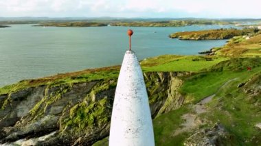 İrlanda, County Cork 'taki Baltimore Beacon' ın Hava Görüntüsü. Güzel Atlantik kıyısında gün batımı. Gün batımında deniz feneri. Günbatımında okyanusun arka planında beyaz deniz feneri. Kayalık yer