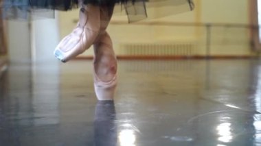 Yerde dans eden sivri uçlu ayakkabılı bir balerinin bacakları. Büyük salonda prova yaparken balerin ayakları. Sıkı çalışma ve dans eğitimi ve klasik koreografi sanatı. Yavaş Hareket