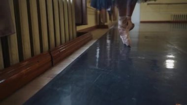 Yerde dans eden sivri uçlu ayakkabılı bir balerinin bacakları. Büyük salonda prova yaparken balerin ayakları. Sıkı çalışma ve dans eğitimi ve klasik koreografi sanatı. Yavaş Hareket