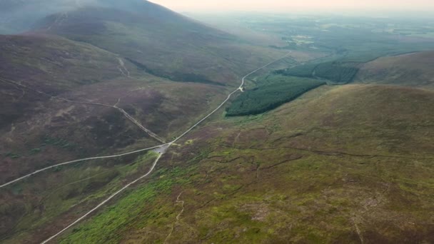 リスモア ウォーターワード アイルランドの緑豊かな森の山の風景を通過する田舎道の空中4Kビュー 山の高い国立公園にある道 道を通り抜ける — ストック動画