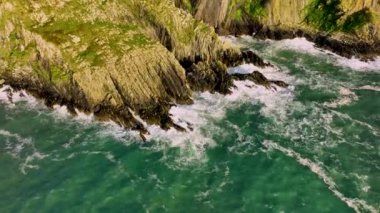 Sahildeki kayalık doğa arka planı. İrlanda, County Cork 'ta Baltimore Beacon' ın saf doğasını geziyorum. Vahşi doğanın sinematik hava manzarası dünyaca ünlü kıyı şeridi. Açık hava macerası ve seyahat