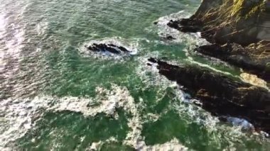 İrlanda 'nın engebeli sahillerinde okyanus dalgaları yıkılıyor. İrlanda, County Cork 'taki Baltimore Beacon' ın Hava Görüntüsü. Güzel Atlantik kıyısında gün batımı. Gün batımında deniz feneri. Beyaz