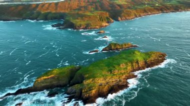 Sahildeki kayalık doğa arka planı. İrlanda, County Cork 'ta Baltimore Beacon' ın saf doğasını geziyorum. Vahşi doğanın sinematik hava manzarası dünyaca ünlü kıyı şeridi. Açık hava macerası ve seyahat