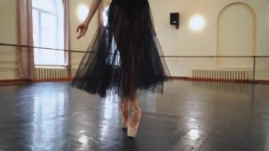 Yerde dans eden sivri uçlu ayakkabılı bir balerinin bacaklarının yakın çekimi. Sıkı çalışma ve dans eğitimi ve klasik koreografi sanatı. Balerin yerinde dönüyordu. Ayakkabılar, bale ve