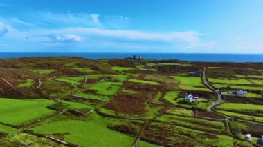 Havadan. Büyük bir adanın tepesinde antik bir deniz feneri. Yeşil bir ada ve İrlanda 'nın ortasındaki antik bir kalenin kalıntıları. Deniz manzarası ve yağmur bulutlarına karşı antik kalıntılar. Deniz feneri
