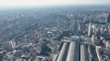 Milano Merkez Tren İstasyonu ve çevresindeki meydanın tarihi binasının havadan görünüşü. İstasyonun hava görüntüsü. İstasyon sütunlarının üzerinde eski geniş kavisli metal ve camdan bir yapı.