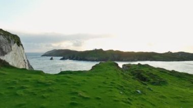 Vahşi doğanın sinematik hava manzarası dünyaca ünlü kıyı şeridi. Açık hava macerası ve seyahat. Okyanus mavisi dalgalar kayalık bir dağın yüksek uçurumunda kırılır. Kumsalda tehlikeli deniz dalgaları. Nefes kesici.