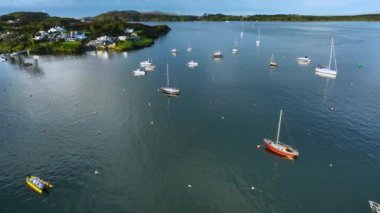 Hava 4k. Baltimore 'un sahil köyü. Okyanus kıyısında pitoresk bir şehir. İrlanda 'da küçük bir kasabanın arka planında beyaz yatlar ve tekneler var. Atlantik Okyanusu kıyısında bir balıkçı kasabası.