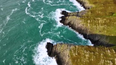 Sahildeki kayalık doğa arka planı. İrlanda, County Cork 'ta Baltimore Beacon' ın saf doğasını geziyorum. Vahşi doğanın sinematik hava manzarası dünyaca ünlü kıyı şeridi. Açık hava macerası ve seyahat