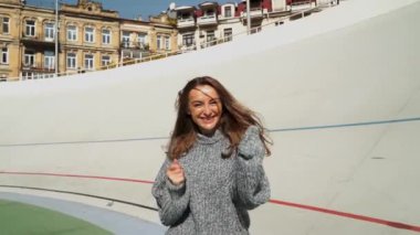 Güzel gülüşlü, dans eden ve zıplayan mutlu bir kız, olumlu duygular. Kafkasyalı mutlu bir kız açık havada dans eder, tek başına eğlenir ve içtenlikle güler. saç farklı şekillerde gelişir.